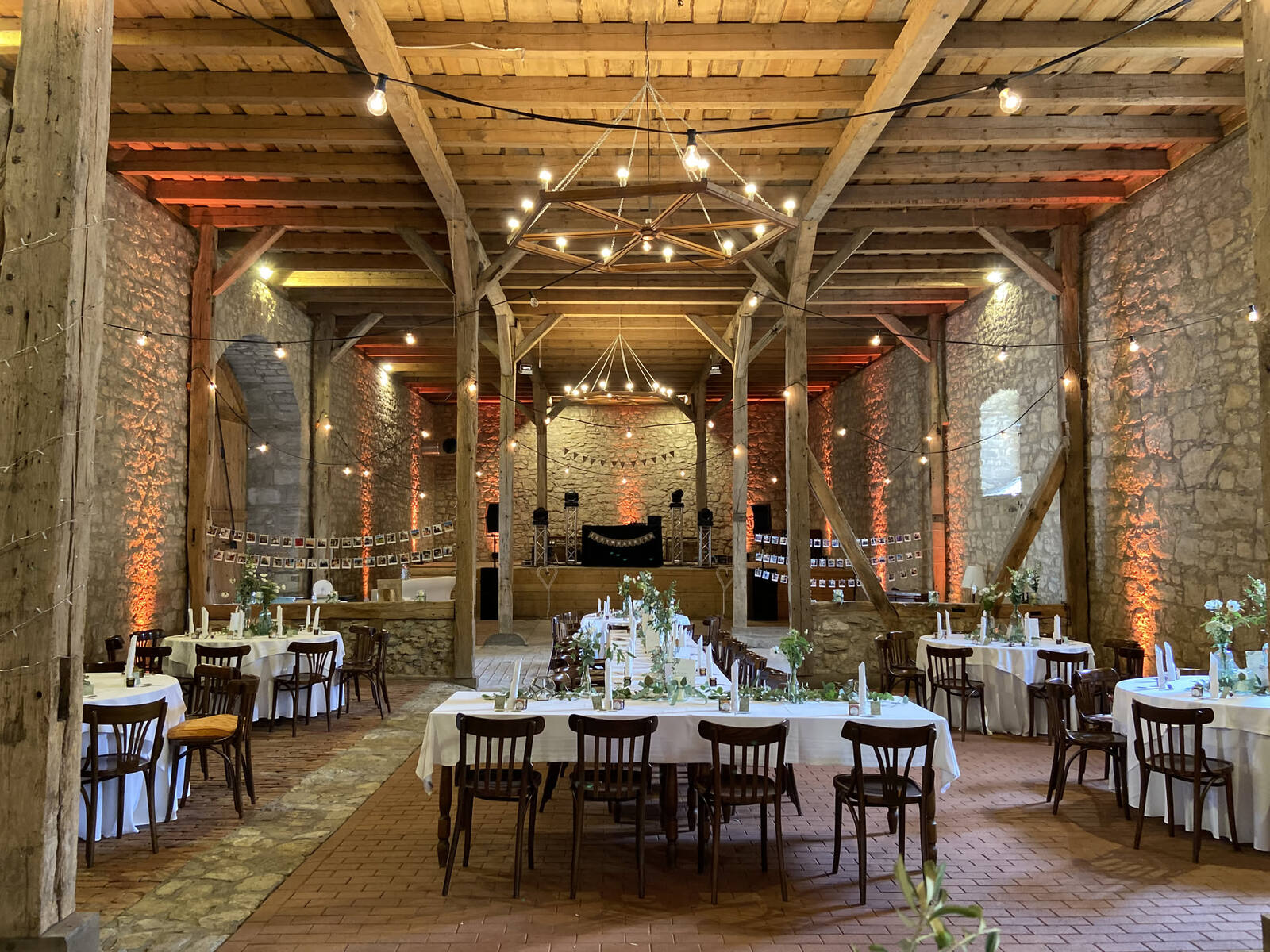 Warm beleuchtete Scheunenlocation mit Lichterketten für eine Hochzeit